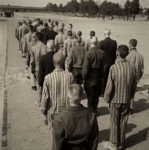 zwart/wit foto van een rij mensen in de karakteristieke gestreepte kamp uniformen in kamp Vught gedurende de Tweede Wereldoorlog