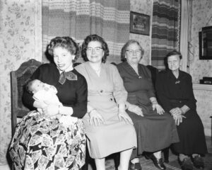zwart-wit foto met vier generaties vrouwen in een woonkamer.
