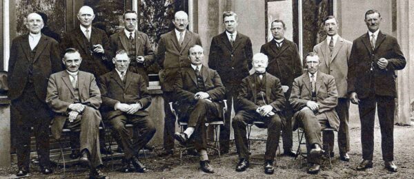 Oude foto waarop een groote groep mannen te zien is. achterste rij staand en voorste rij zittend.